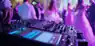 DJ mixing music at a lively wedding party in a luxury event space.